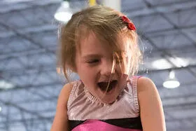 Girl taking first Gymnastics moves and smiling